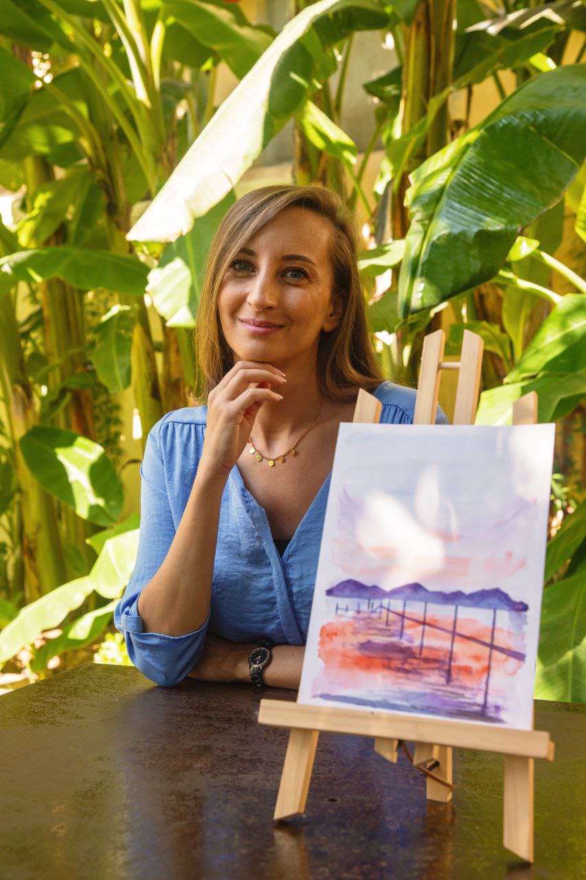 Marie posing with one of her paintings